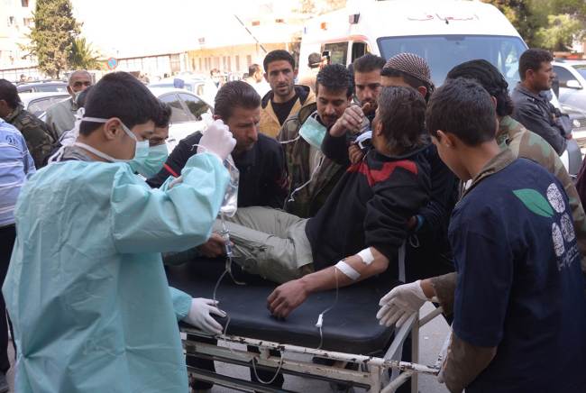 A man is brought to a hospital in the Khan al-Assal region in the northern Aleppo province, Syria, Tuesday, as Syria’s government accused rebel forces of using chemical weapons for the first time.   AFP-Yonhap News