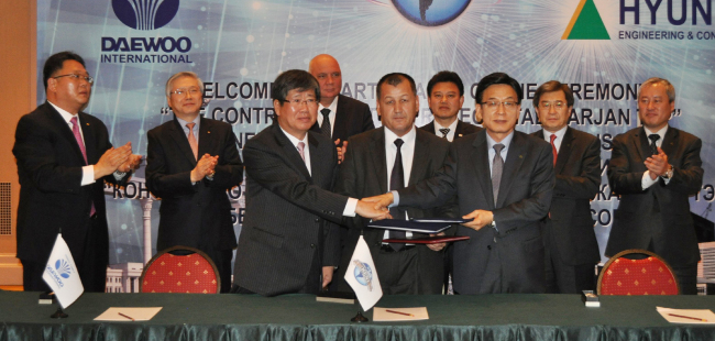 Daewoo International Corp. vice chairman Lee Dong-hee (from left, front row), Uzbekenergo director Basidov and Hyundai Engineering & Construction president Jung Soo-hyun shake hands after signing a deal to build a power plant at a ceremony in Tashkent on Tuesday.   Hyundai E&C