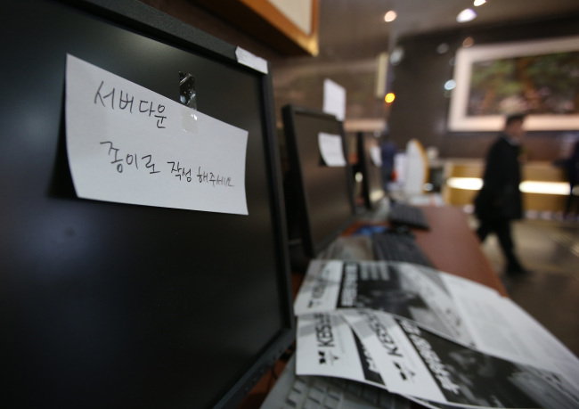 A handwritten note informing of the computer system failure is stuck on a computer monitor in a KBS office in Seoul.   Yonhap News