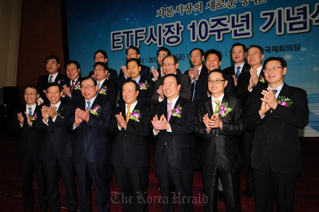 Ranking officials from the Korea Exchange, including chairman Kim Bong-soo (center, front row), pose during an event to celebrate the 10th anniversary of the opening of the exchange-traded fund market at the main bourse in Yeouido, Seoul, in October 2012.   KRX