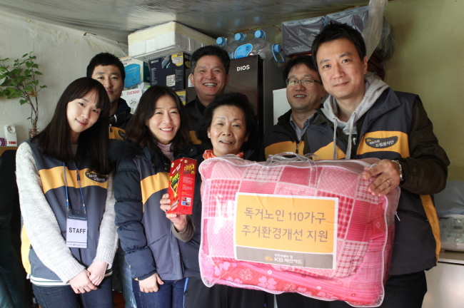 KB Kookmin Card officials pose after cleaning the home of an elderly woman and presenting her with everyday necessities as part of their volunteer community services for 110 elderly households.   KB Kookmin Card