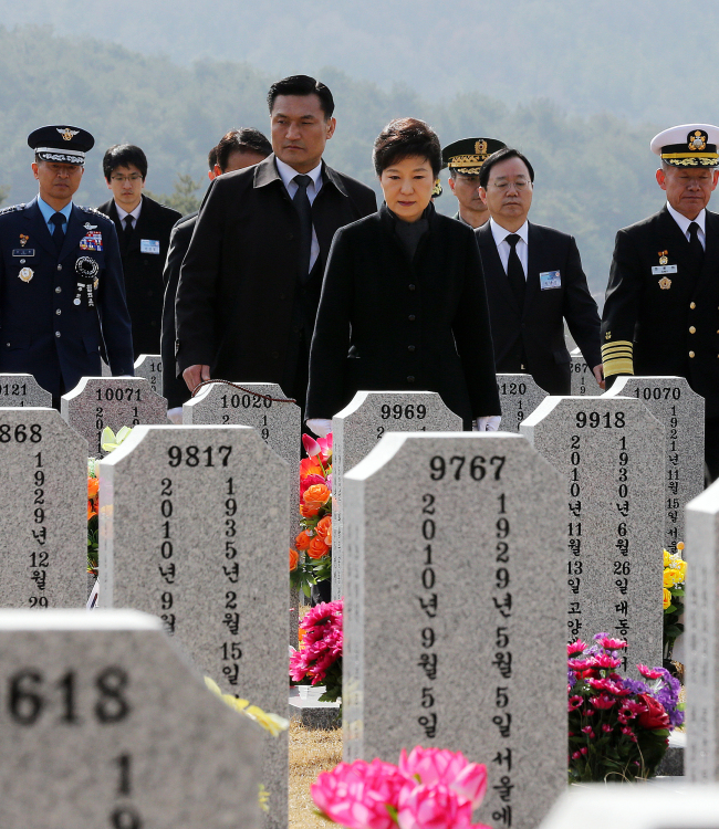 President Park Geun-hye walks to the grave of Han Joo-ho, the chief warrant officer who died during a search and rescue operation, at Daejeon National Cemetery ahead of the event marking the third anniversary of the sinking of the South Korean warship Cheonan on Tuesday.   Yonhap News