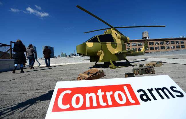 A replica of a camouflage military-style helicopter stands on a rooftop across Manhattan’s skyline and the United Nations headquarters during a campaign by Control Arms Coalition activists in New York on Wednesday.    AFP-Yonhap News