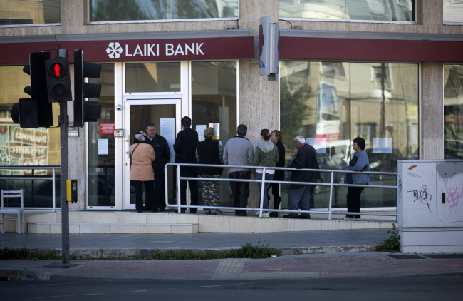 Customers queue outside a branch of Laiki Bank in Nicosia, Cyprus, Friday.   Bloomberg