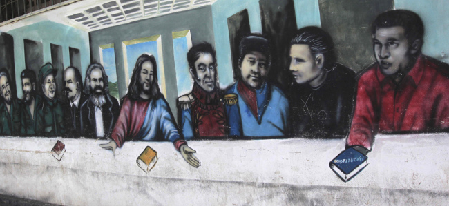 A mural imitating the religious painting the Last Supper covers a wall of a popular housing complex, showing (from left to right) Fidel Castro, Ernesto “Che” Guevara, Mao Tse-tung, Vladimir Lenin, Karl Marx, Jesus Christ, Simon Bolivar, Venezuelan rebel fighters Alexis Gonzalez and Fabricio Ojeda and Venezuela’s late President Hugo Chavez in Caracas on March 5.   AP-Yonhap News