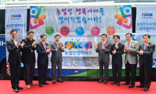 NongHyup chairman Choi Won-byung (fourth from right), Shin Joon-shik (fourth from left), founder of Jaseng Hospital of Oriental Medicine, and others launch the “Farmers’ Happiness Bus,” a joint welfare project for farmers, at NongHyup in Seoul on Tuesday.   Lee Sang-sub/The Korea Herald