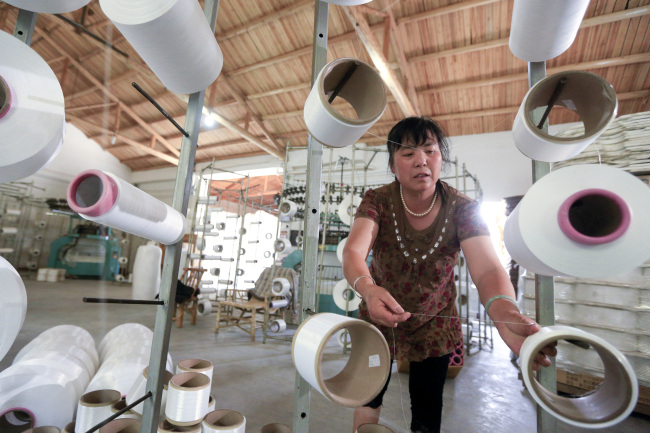 An employee works in a factory producing textiles in Shaoxing, Zhejiang Province, China.   Bloomberg