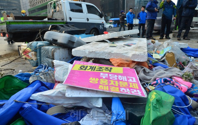 4일 새벽 5시 50분경 서울 중구청이 직원 50여명을 투입해 덕수궁 대한문 앞 쌍용자동차 천막 농성장을 기습철거에 나서  오전 6시쯤 철거를 마쳤다. 중구청 직원이 철거 물건을 차량에 싣고 있다.쌍용차 노조 관계자는 "중구청과 협의가 진행 중이었고 중구청장 면담 또한 협의 중 이었던 점을 감안하면 기습 철거는 만행"이라고 비판했다.<br />이상섭 기자. babtong@heraldcorp.com 2013.04.04
4일 새벽 5시 50분경 서울 중구청이 직원 50여명을 투입해 덕수궁 대한문 앞 쌍용자동차 천막 농성장을 기습철거에 나서  오전 6시쯤 철거를 마쳤다. 중구청 직원이 철거 물건을 차량에 싣고 있다.쌍용차 노조 관계자는 "중구청과 협의가 진행 중이었고 중구청장 면담 또한 협의 중 이었던 점을 감안하면 기습 철거는 만행"이라고 비판했다.
이상섭 기자. babtong@heraldcorp.com 2013.04.04