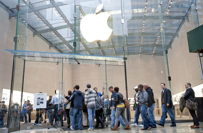 Customers enter an Apple Inc. store in New York.   Bloomberg