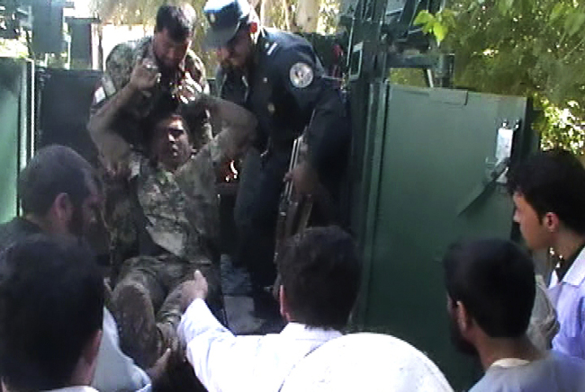 This image taken from AP video shows an injured Afghan National Army soldier taken from a military vehicle outside a hospital in Farah, western Afghanistan, Wednesday.   AP-Yonhap News