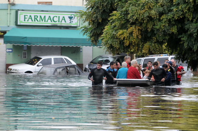 Local residents are evacuated at a flooded area after a storm, in Tolosa, La Plata, 63 kilometers south of Buenos Aires, Wednesday.   Xinhua-Yonhap News