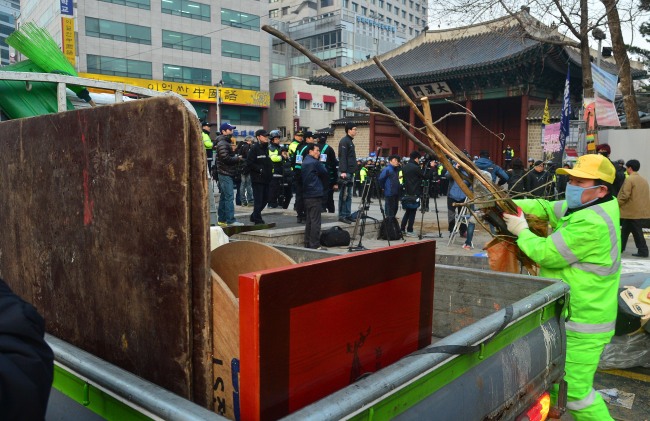 Workers from Jung-gu district office remove tents and desks used by sit-in protesters from Ssangyong Motor Co. since April 2012 in front of Deoksu Palace in central Seoul early Thursday morning. (Related story on Page 3)   Lee Sang-sub/The Korea Herald