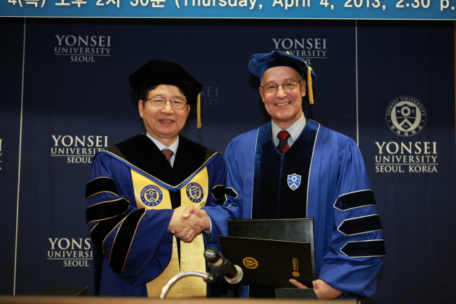 Andrew Hamilton (right), vice-chancellor of the University of Oxford, shakes hands with Yonsei University president Jeong Kap-young after receiving an honorary doctorate degree from the Korean school on Thursday.   Yonsei University