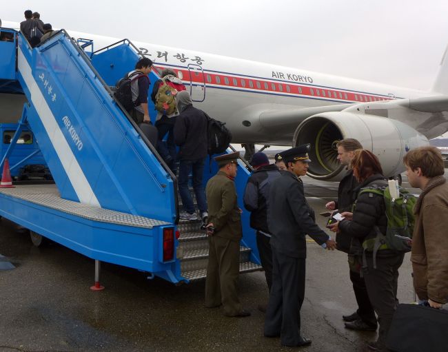 North Korean officials check the passports of a group of foreign diplomats and tourists as they board an Air Koryo flight to Beijing at the airport in Pyongyang on Saturday. Foreign diplomats in North Korea appeared to be staying put, ignoring a warning by Pyongyang that they should consider evacuating their missions amid soaring tensions.   AFP-Yonhap News