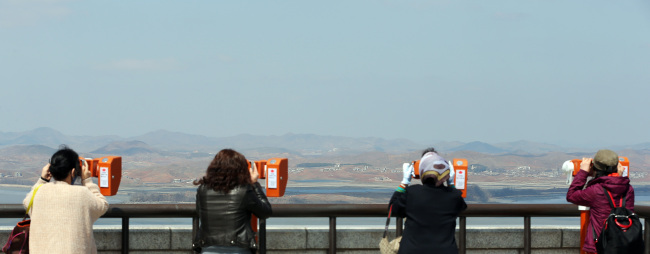 Visitors look through binoculars at North Korea at the Unification Observatory in Paju in northern Gyeonngi Province amid continuing threats of war on Sunday.   Yonhap News