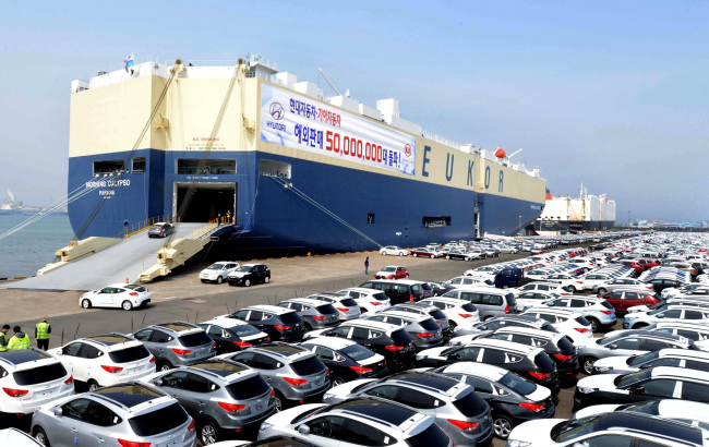Hyundai Motor vehicles wait for shipment in front of a transporter ship in Ulsan.    Hyundai Motor