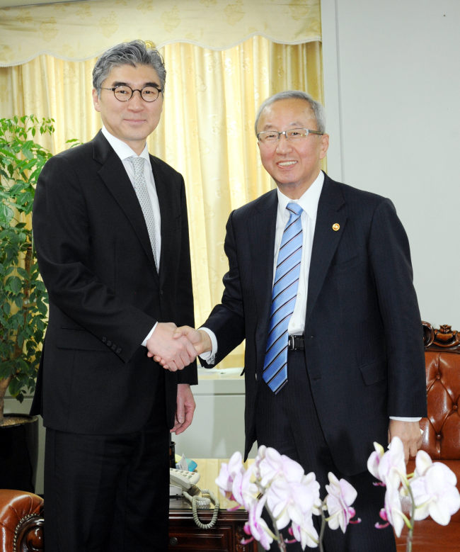 Finance Minister Hyun Oh-seok (right) greets U.S. Ambassador to Korea Sung Kim before holding talks in Seoul on Monday.   Finance Ministry