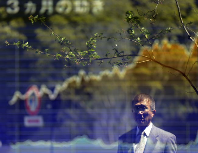 A man looks at an electronic stock board of a securities firm in Tokyo Monday. (AP-Yonhap News)