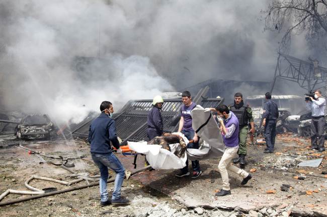 <YONHAP PHOTO-0708> TOPSHOTS - GRAPHIC CONTENT..Rescue teams recover bodies from the scene of a car bomb explosion which rocked central Damascus on April 8, 2013. The blast, which was followed by intense gunfire, occurred near the Syrian central bank causing deaths and injuries, according to Syria's state television. AFP PHOTO/LOUAI BESHARA../2013-04-09 05:53:01/ <저작권자 ⓒ 1980-2013 ㈜연합뉴스. 무단 전재 재배포 금지.>
Rescue teams recover bodies from the scene of a car bomb explosion which rocked central Damascus on Monday.   AFP-Yonhap News