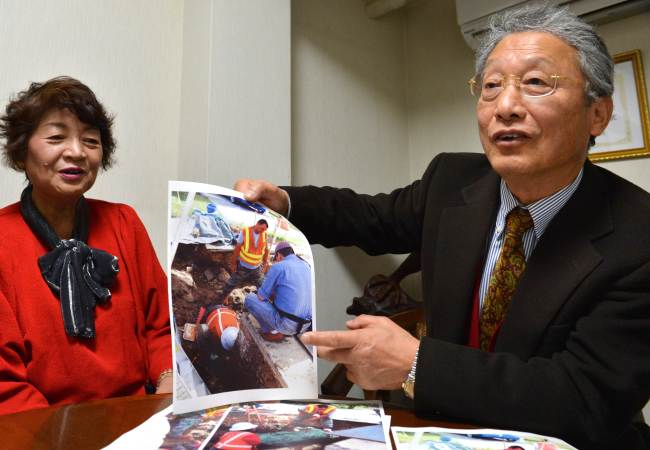 Japanese businessman Heitaro Matsumoto (right) and his colleague Sumiko Naito (left), volunteer to repatriate the remains of fallen Japanese soldiers, and showed images of their work during an interview in Tokyo on Feb. 5.   AFP-Yonhap News