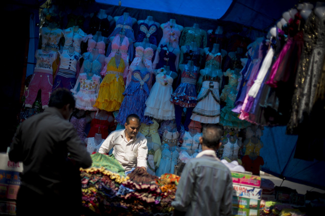 A vendor sets up a clothing stall in the New Market area of Kolkata, India.   Bloomberg