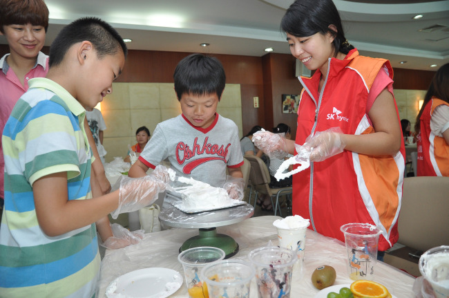Chinese students learn how to make cake with the help of an employee at SK Hynix’s Chinese unit in Wuxi, a coastal city of Jiangsu province, in July last year.   SK Hynix