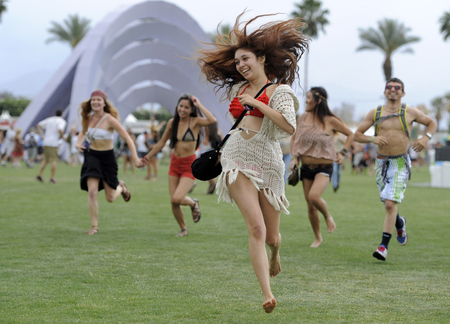 This April 13, 2012 file photo shows festivalgoers running toward the main stage to catch the beginning of Kendrick Lamar’s set during the first weekend of the 2012 Coachella Valley Music and Arts Festival in Indio, California.  AP-Yonhap News
