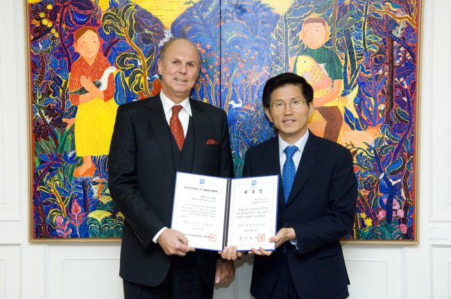 Gyeonggi Gov. Kim Moon-soo (right) and Merck Korea CEO Juergen Koenig pose at a ceremony to grant a letter of appointment as an adviser for promotion of investment in the province on Wednesday.   Merck Korea