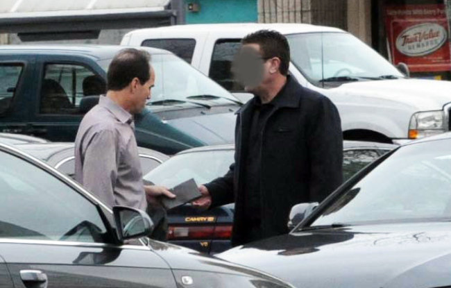In this undated FBI photo provided by the U.S. attorney’s office, KPMG partner Scott London (left) allegedly accepts a $5,000 cash bribe from Bryan Shaw earlier this year. Federal prosecutors have charged London with providing Shaw with inside information on two California companies, Herbalife Ltd. and Skechers USA Inc. Shaw’s face was obscured by the source of the photo.   AP-Yonhap News