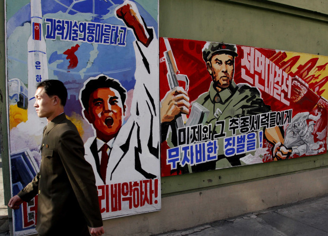 North Korean man walks past propaganda posters in Pyongyang, North Korea. (AP-Yonhap News)