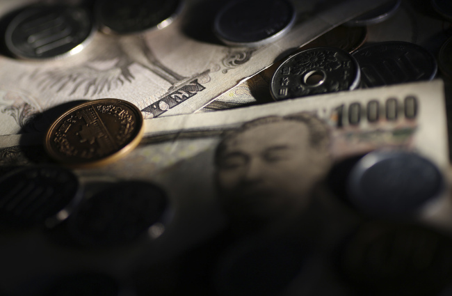 Japanese 10,000 yen banknotes and coins are arranged for a photograph in Tokyo.  Bloomberg