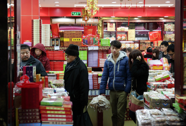 Customers shop at a store selling snacks in Shanghai.   Bloomberg