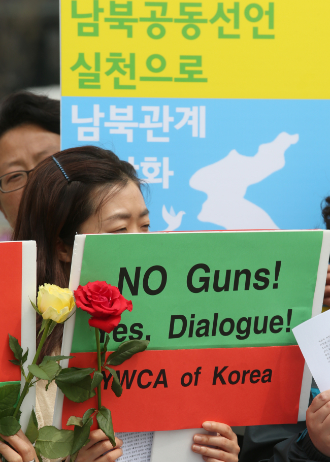 Women’s rights activists hold a rally in Seoul on Tuesday demanding peaceful resolution to tensions on the Korean Peninsula.   Yonhap News