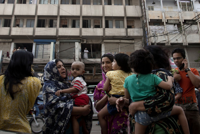 People evacuate buildings and gather on the road as a tremor was felt in Karachi, Pakistan, Tuesday.   AP-Yonhap News