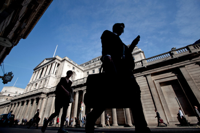 Pedestrians and businessmen pass the Bank of England in London.   Bloomberg