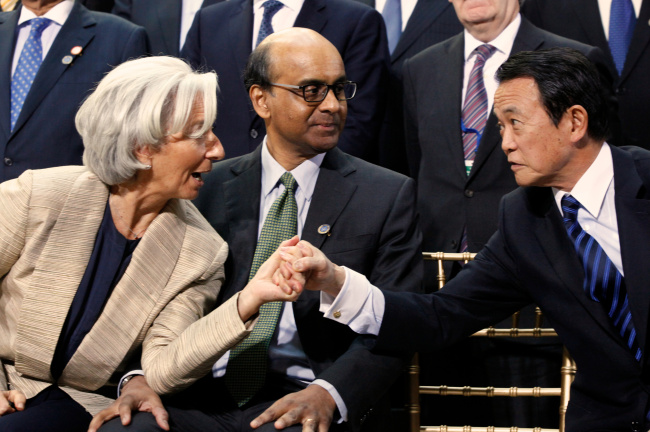 International Monetary Fund Managing Director Christine Lagarde (left) talks with IMF Committee Chair Tharman Shanmugaratnam (center) and Japan’s Minister of Finance Taro Aso before the IMF family photo during the World Bank IMF Spring Meetings in Washington on Saturday.   AP-Yonhap News