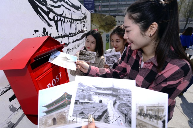 문화재청과 한국문화재보호재단이 21일 오전 서울 광화문 광장에서 '문화융성 희망우체통'을 만들어 5년 3개월 만에 국민에게 돌아오는 숭례문 복구 기념 사전행사를 가지고 있다. 시민들이 희망엽서를 작성해 미래의 희망을 쓴 엽서를 희망우체통에 넣고 있다. 박해묵 기자/mook@heraldcorp.com