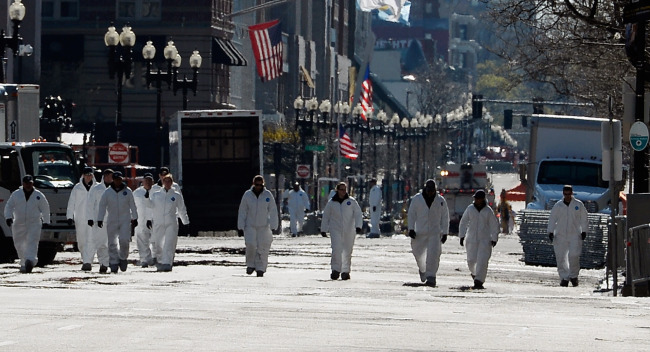Law enforcement investigators walk the route of the Boston Marathon on Boylston Street looking for evidence after last Monday’s bombings and two days after the second suspect was captured in Boston, Massachusetts, Sunday.   AFP-Yonhap News
