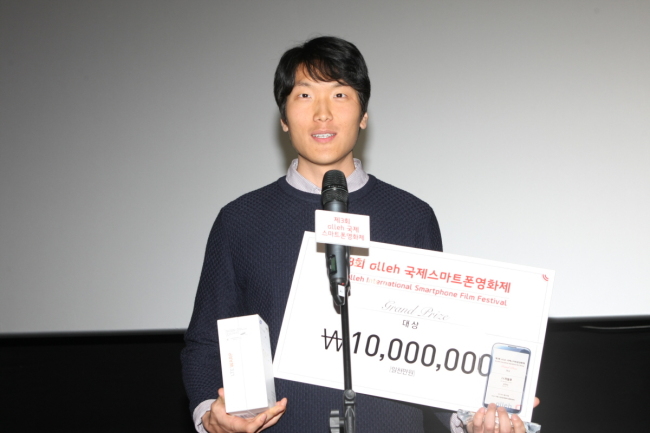 Filmmaker Kim Chan-nyeon receives the top prize at the closing ceremony of the Olleh International Smartphone Film Festival in Seoul on Sunday.   Olleh International Smartphone Film Festival