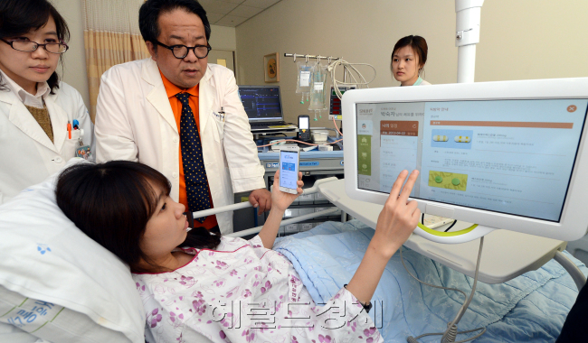 22일 오전 경기도 성남시 분당구 분당서울대병원에서 SK텔레콤과 서울대 병원의 조인트 벤처 헬스커넥트가 ICT(정보통신기술)을 활용한 환자 맞춤형 시스템 '스마트병원 솔루션'을 선보이고 있다. 이 솔루션은 환자와 병원 방문객이 스마트폰과 무인안내시스템, 태블릿PC 등 IT 기기를 이용해 진료·검사 접수, 병원 행정 업무 처리, 의료 정보 조회, 대기 시간 확인, 진료비 결제, 시설 위치 정보를 확인할 수 있는 시스템이다./안훈기자 rosedale@ 2013.04.22
22일 오전 경기도 성남시 분당구 분당서울대병원에서 SK텔레콤과 서울대 병원의 조인트 벤처 헬스커넥트가 ICT(정보통신기술)을 활용한 환자 맞춤형 시스템 '스마트병원 솔루션'을 선보이고 있다. 이 솔루션은 환자와 병원 방문객이 스마트폰과 무인안내시스템, 태블릿PC 등 IT 기기를 이용해 진료·검사 접수, 병원 행정 업무 처리, 의료 정보 조회, 대기 시간 확인, 진료비 결제, 시설 위치 정보를 확인할 수 있는 시스템이다./안훈기자 rosedale@ 2013.04.22
