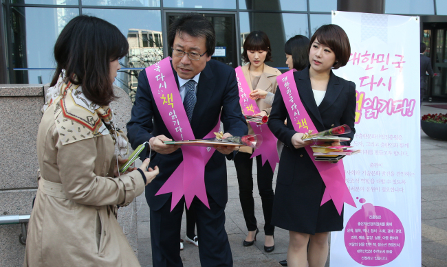 President Lee Jae-ho (center) and staff of the Publication Industry Promotion Agency of Korea give out brochures, roses, and children’s books in Gwanghwamun.   Yonhap News