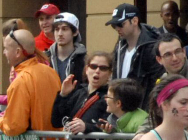 This April 15 photo provided by Bob Leonard shows bombing suspects Tamerlan Tsarnaev (center right in black hat) and his brother, Dzhokhar A. Tsarnaev (center left in white hat), approximately 10-20 minutes before the blasts that struck the Boston Marathon.   AP-Yonhap News