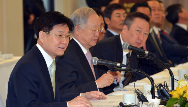 Tax chief Kim Duk-joong (left) speaks at a meeting with a group of entrepreneurs organized by the Korea Chamber of Commerce and Industry in Seoul on Thursday. Next to him are KCCI chairman Sohn Kyung-shik (center) and Doosan Group chairman Park Yong-maan.   Kim Myung-sub/The Korea Herald