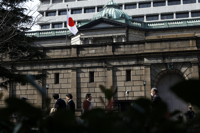 Pedestrians walk past the Bank of Japan headquarters in Tokyo.  Bloomberg