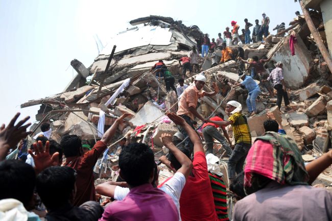 Bangladeshi volunteers and rescue workers assist in rescue operations after an eight-story building collapsed in Savar, on the outskirts of Dhaka, Friday.   AFP-Yonhap News