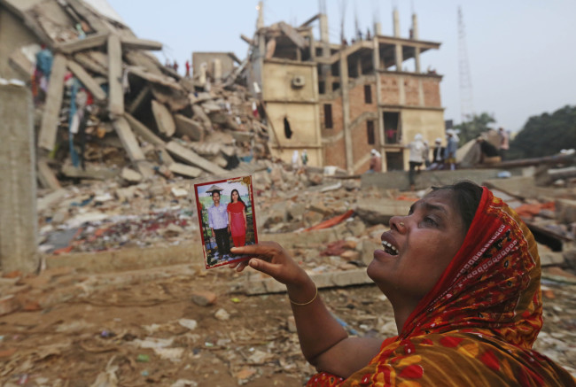 A Bangladeshi woman weeps as she holds a picture of her and her missing husband as she waits at the site of a building that collapsed Wednesday in Savar, near Dhaka, Bangladesh, Friday.
AP-Yonhap News