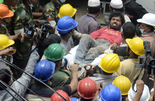 <YONHAP PHOTO-0074> A survivor is pulled out of the rubble of the garment factory building that collapsed Wednesday in Savar, near Dhaka, Bangladesh, Sunday April 28, 2013. A fire broke out late Sunday in the wreckage of the garment factory that collapsed last week in Bangladesh, with smoke pouring from the piles of shattered concrete and some of the rescue efforts forced to stop. The fire came four days after the collapse, as rescuers were trying to free a woman they found trapped in the rubble.(AP Photo/Ismail Ferdous)/2013-04-29 07:02:47/ <저작권자 ⓒ 1980-2013 ㈜연합뉴스. 무단 전재 재배포 금지.>
A survivor is pulled out of the rubble of the garment factory building that collapsed Wednesday in Savar, near Dhaka, Bangladesh, Sunday.   AP-Yonhap News