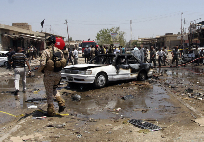 Civilians and security forces gather at the scene of a car bomb attack in the southern Shiite city of Karbala, 80 kilometers south of Baghdad, Monday.   AP-Yonhap News