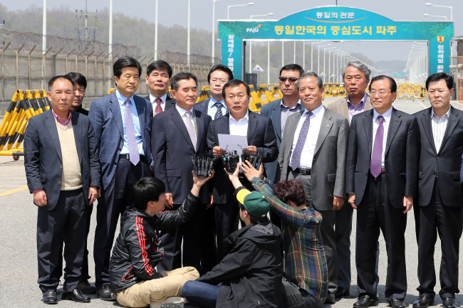 Han Jae-kwon (center), head of the Gaeseong Industrial Complex Companies Association, speaks to reporters near the checkpoint of the Unification Bridge in Paju, Gyeonggi Province, after being refused entry to the inter-Korean industrial park on Tuesday. (Yonhap News)