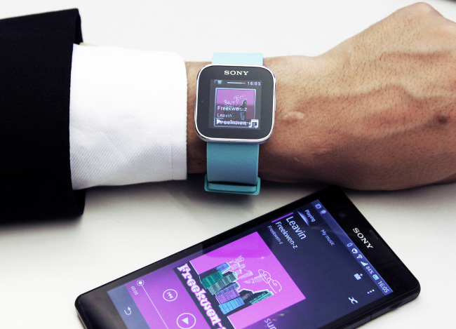A Sony Mobile Communications Inc. SmartWatch MN2 (top) is displayed with the company’s Xperia smartphone at the Sony Corp. headquarters in Tokyo.    Bloomberg